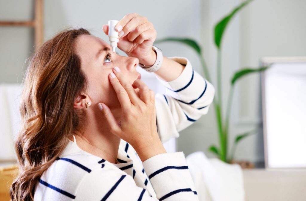 A person with dry eye applies artificial tears to treat their irritation.