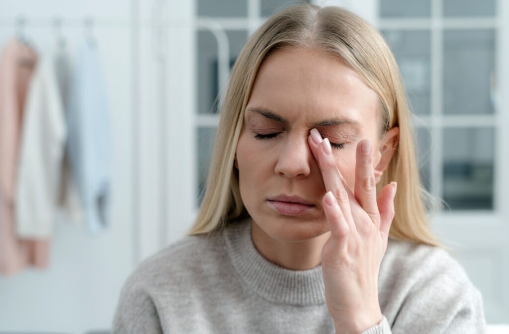 Closeup of someone rubbing their eye in pain.