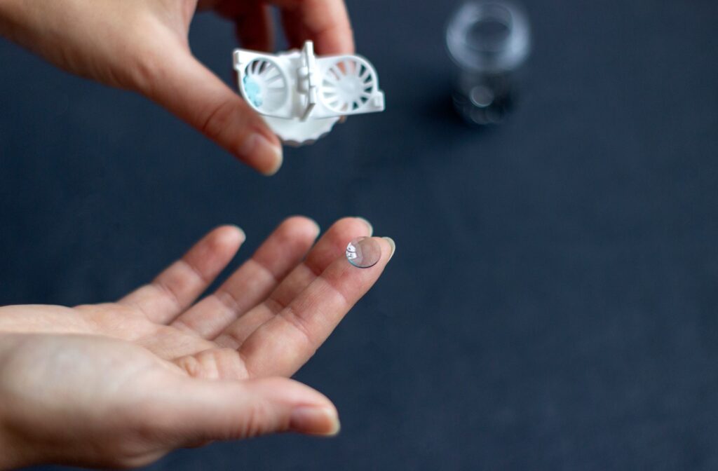 Hand holding a clear contact lens for vision correction and eye care