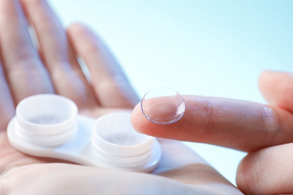 A close up of someone holding a contact lens on their finger